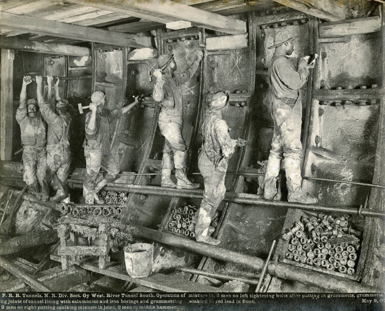 African American sandhog crew tightening bolts inside the Hudson River tunnel, May 9, 1907.